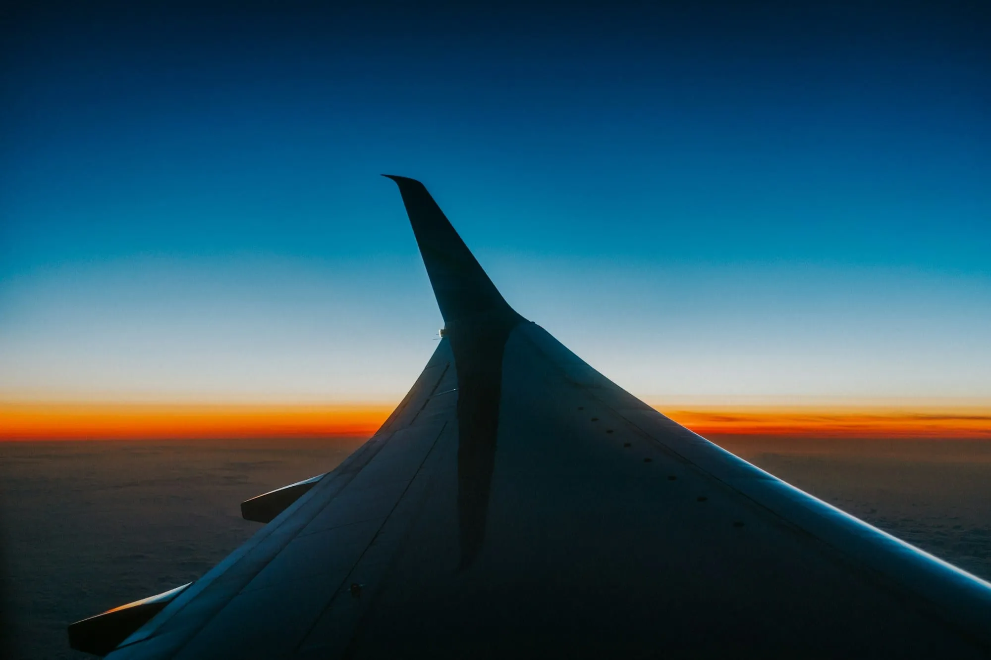 Aeroplane wing above the clouds at dusk